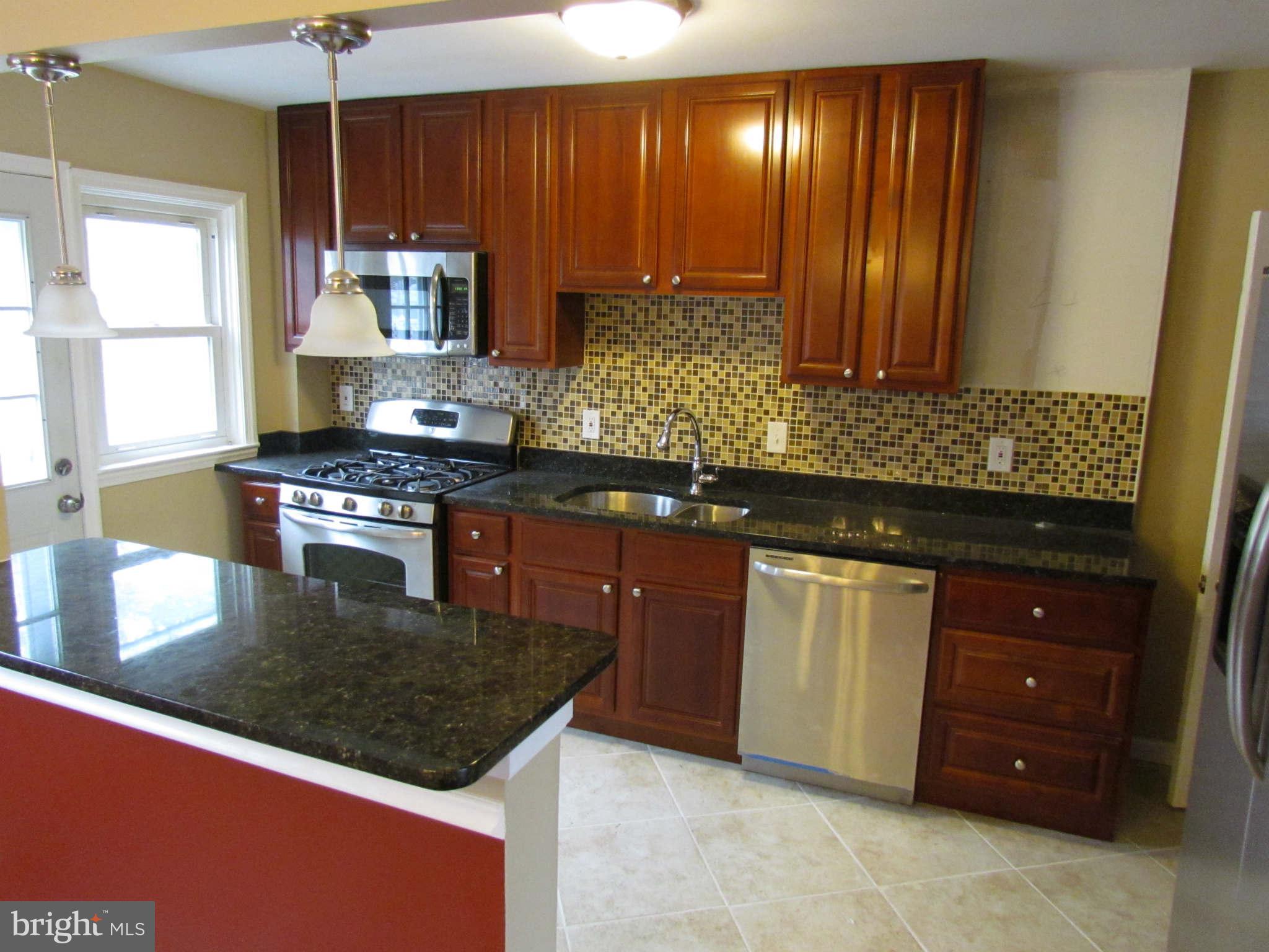 1604 Northbourne Road Baltimore, MD 21239 - Photo 1 of 12 a kitchen with stainless steel appliances granite countertop a stove a sink and a microwave