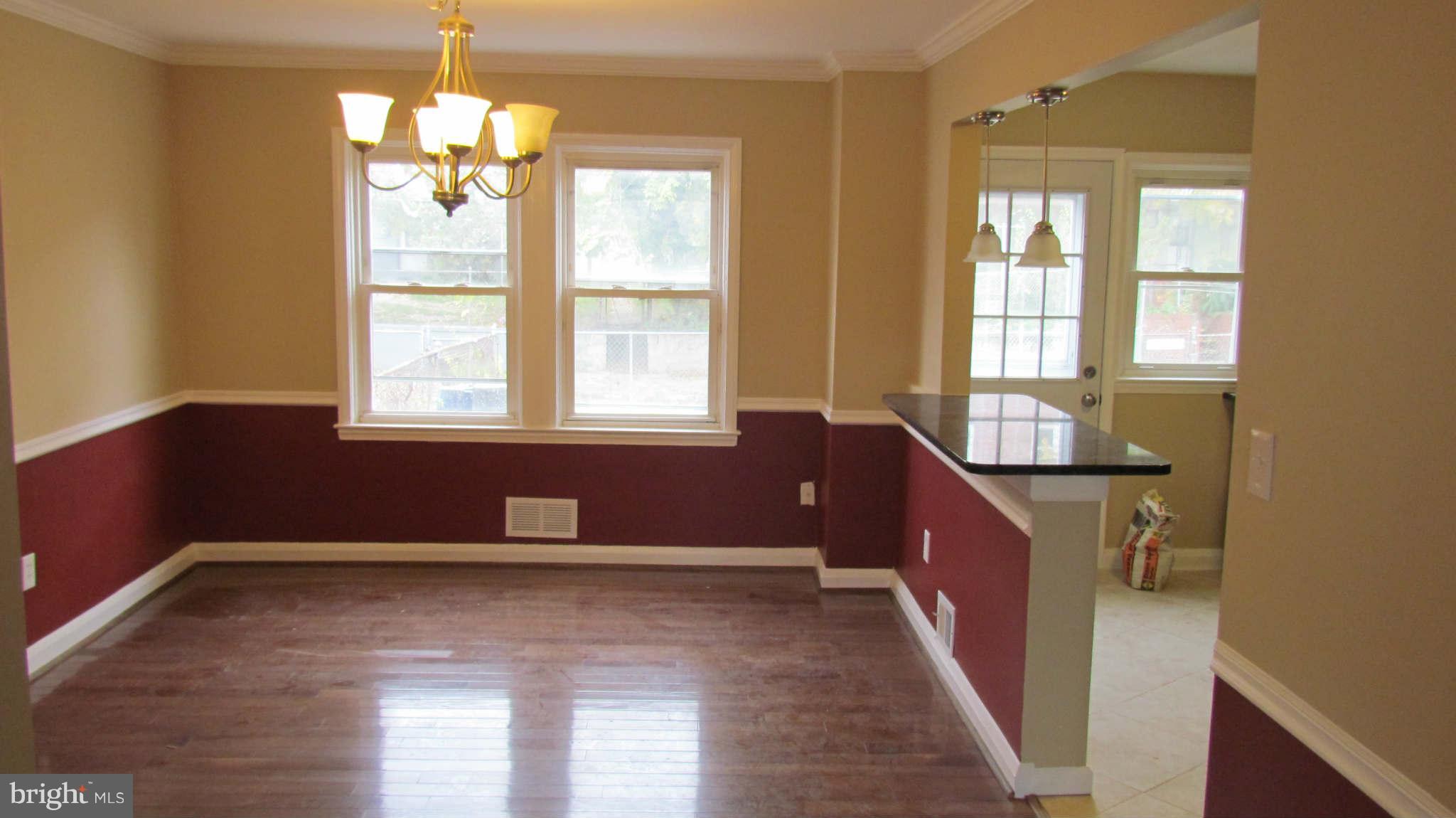 1604 Northbourne Road Baltimore, MD 21239 - Photo 3 of 12 a view of an empty room with wooden floor and a window