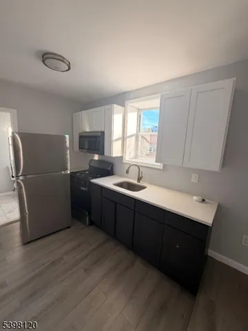 a kitchen with a refrigerator sink and wooden cabinets