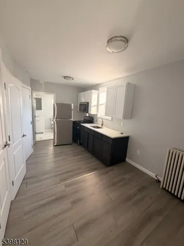 a kitchen with stainless steel appliances kitchen island a cabinets and wooden floor