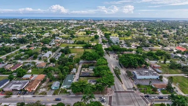 an aerial view of residential houses with outdoor space and trees