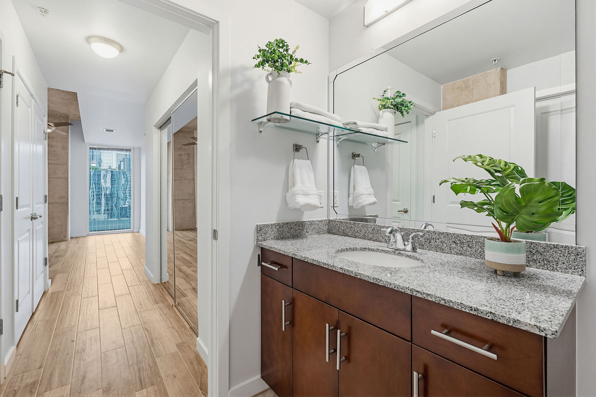 360 Nueces Street, Unit 1505 Austin, TX 78701 - Photo 14 of 28 a bathroom with a granite countertop sink a potted plant and a shower