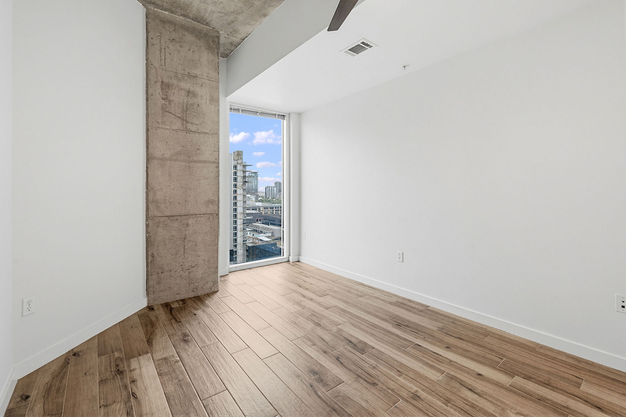 360 Nueces Street, Unit 1505 Austin, TX 78701 - Photo 16 of 28 a view of an empty room with wooden floor and a window