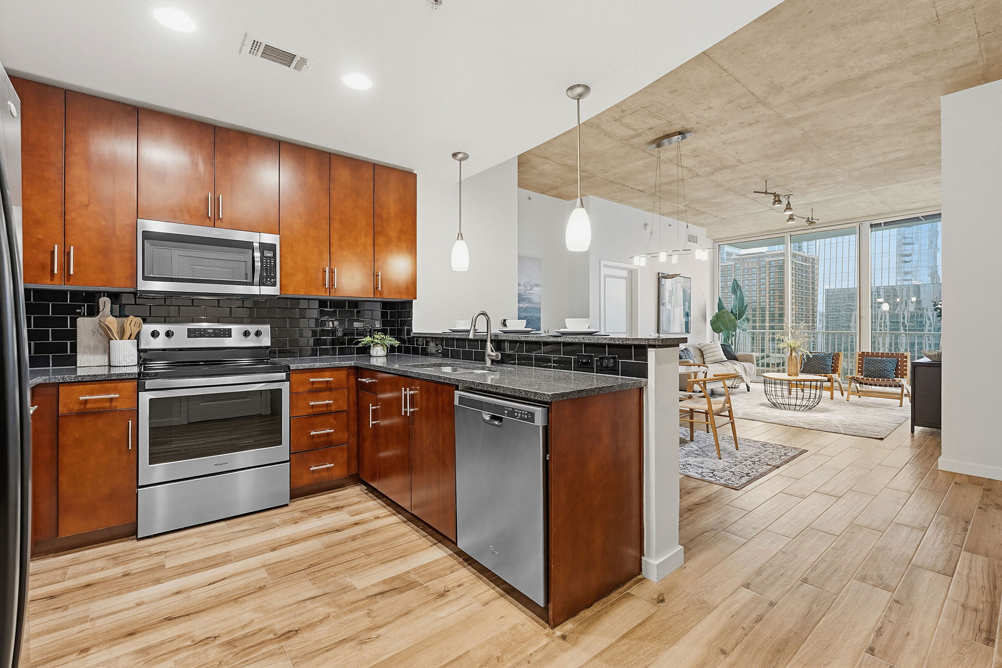 360 Nueces Street, Unit 1505 Austin, TX 78701 - Photo 7 of 28 a kitchen with stainless steel appliances wooden cabinets and a stove top oven