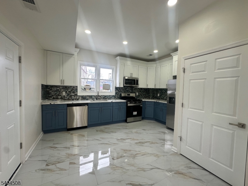 13 Vermont Avenue, Unit 2 Newark, NJ 07106 - Photo 5 of 20 a large kitchen with granite countertop a stove cabinets and a refrigerator