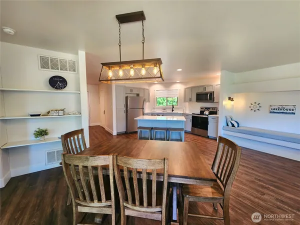 a view of kitchen with refrigerator and wooden floor