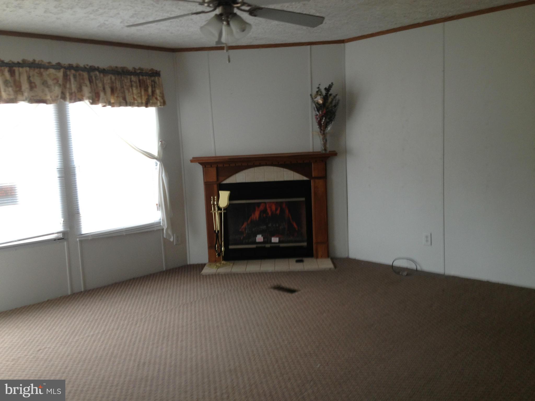 45200 Happyland Road Valley Lee, MD 20692 - Photo 3 of 24 a living room with a fireplace and a window
