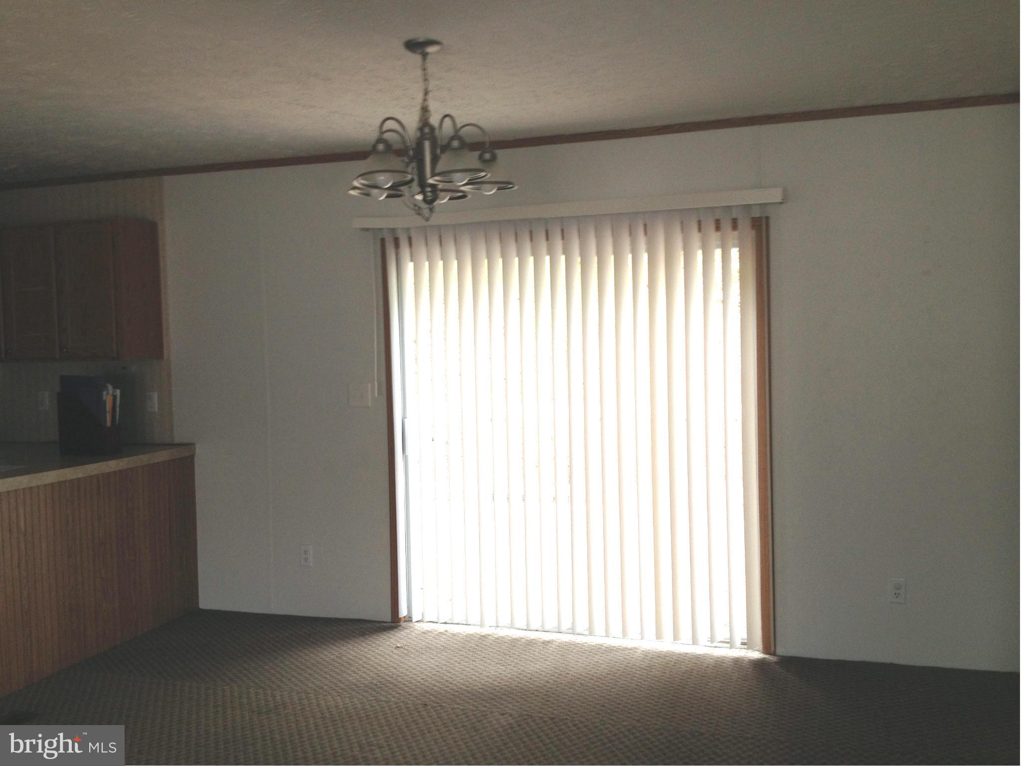 45200 Happyland Road Valley Lee, MD 20692 - Photo 4 of 24 an empty room with chandelier fan and windows