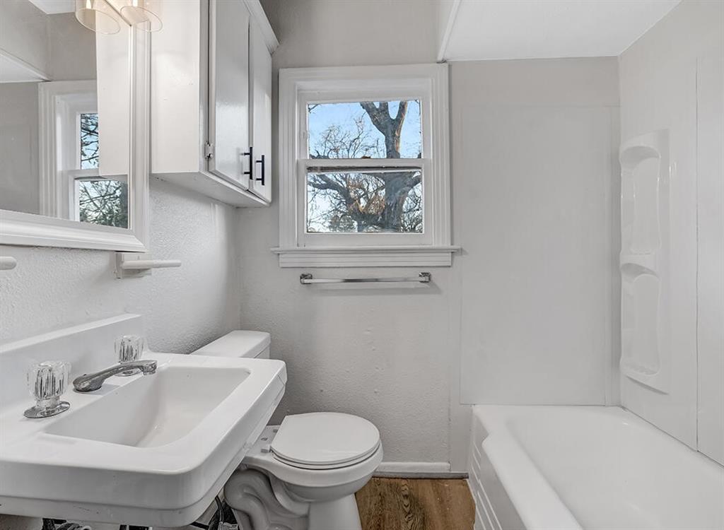 828 Unity Drive Wake Village, TX 75501 - Photo 13 of 14 a bathroom with a sink and mirror with toilet