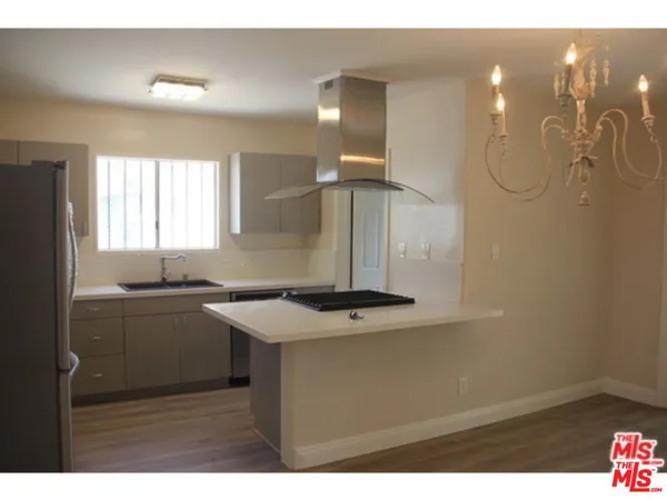 a kitchen with a sink a refrigerator and cabinets