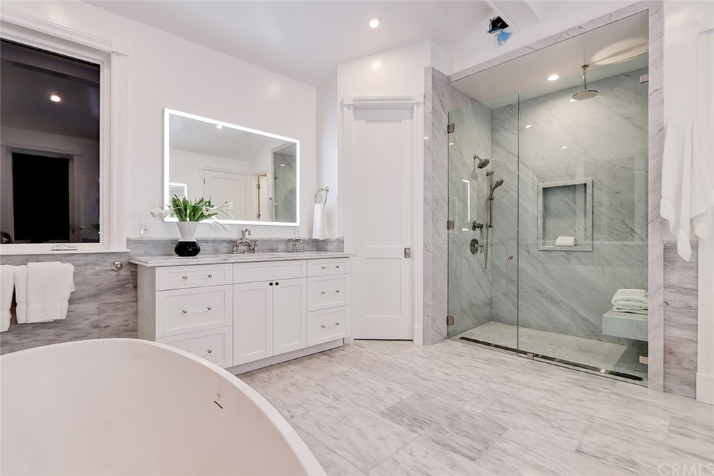 1751 8th Street Manhattan Beach, CA 90266 - Photo 35 of 43 a spacious bathroom with a granite countertop sink mirror and shower
