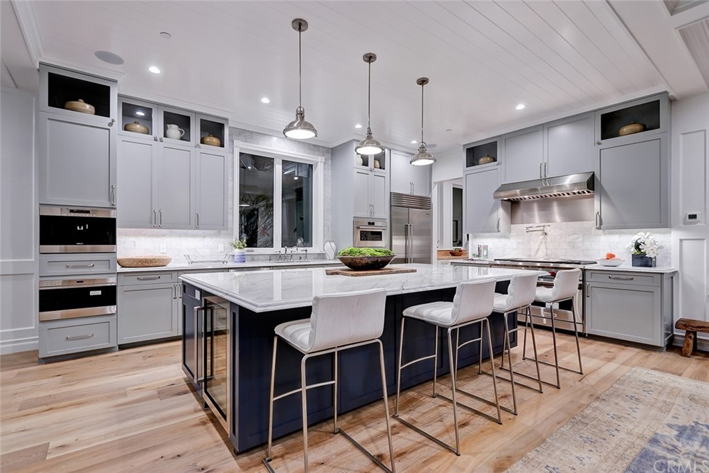 1751 8th Street Manhattan Beach, CA 90266 - Photo 10 of 43 a kitchen with stainless steel appliances granite countertop a stove top oven a sink dishwasher a dining table and chairs with wooden floor