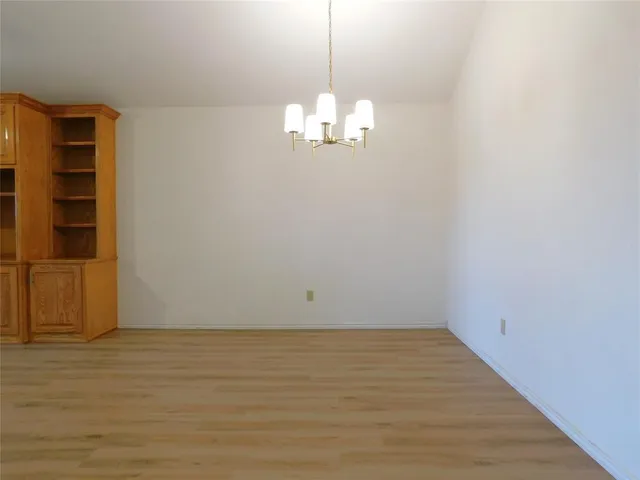 a view of a room with wooden floor and cabinet