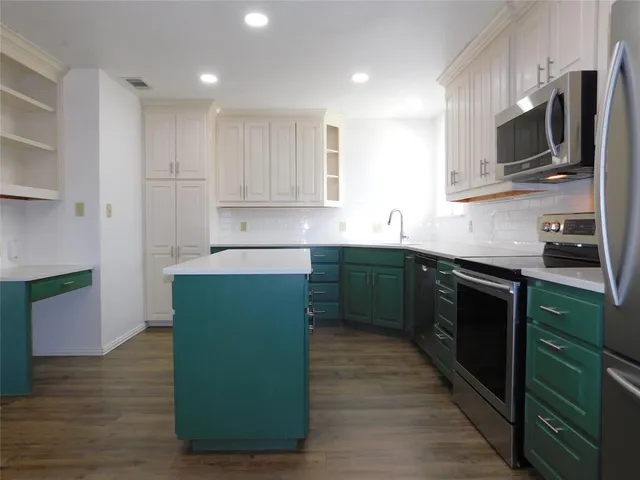 a kitchen with kitchen island granite countertop a sink counter top space stainless steel appliances and cabinets