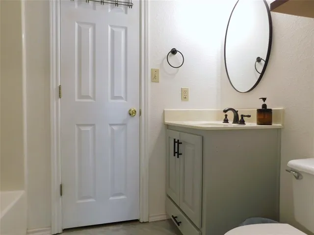 a bathroom with a sink mirror and toilet