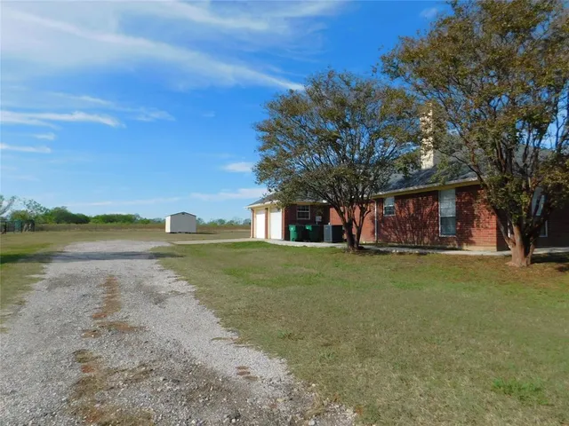 a front view of a house with a yard and lake view