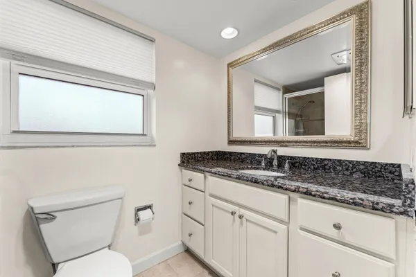 a bathroom with a toilet a sink and mirror