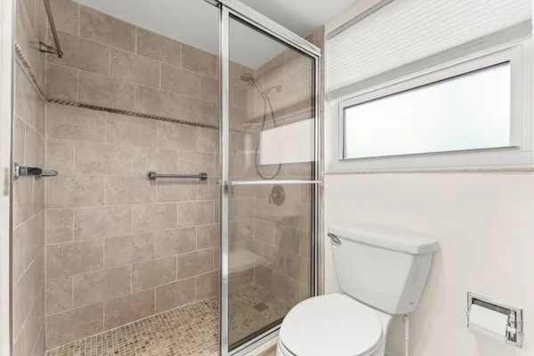 a white toilet sitting next to a shower