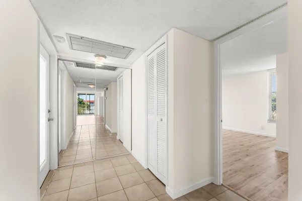 a view of a hallway with wooden cabinets