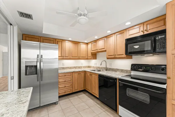 a kitchen with stainless steel appliances granite countertop a stove top oven a refrigerator a sink and dishwasher