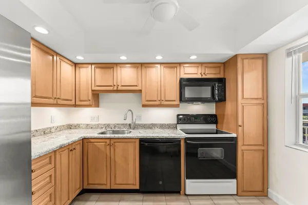 a kitchen with stainless steel appliances granite countertop a stove a sink and a microwave