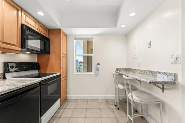 a kitchen that has a microwave a stove and white cabinets