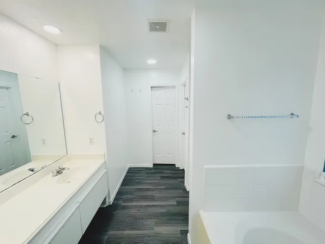 a bathroom with a double vanity sink and mirror with shower