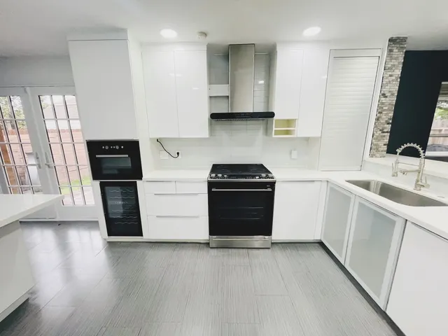 a kitchen with stainless steel appliances a stove top oven a sink and a refrigerator