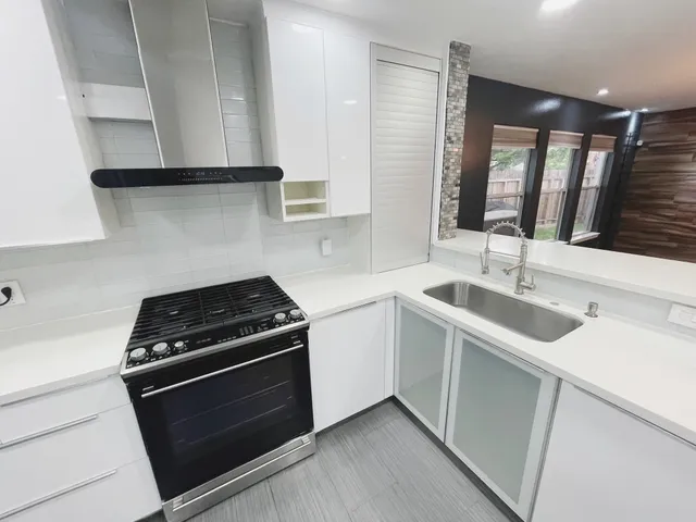 a kitchen with granite countertop white cabinets stainless steel appliances and sink