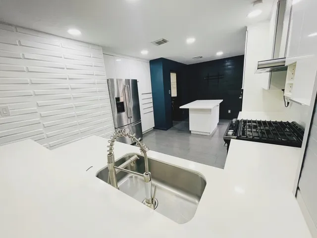 a kitchen with a sink and a stove top oven