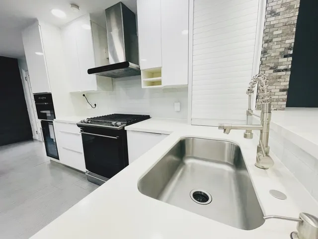 a kitchen with a sink and a stove top oven