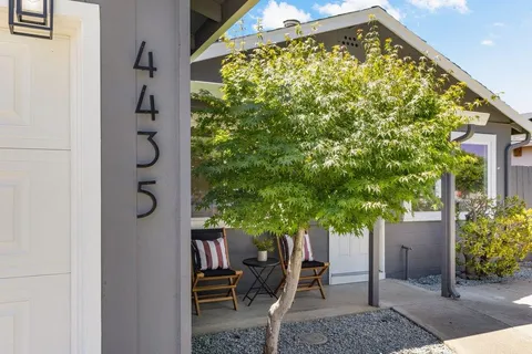 a view of patio with a table and chairs and potted plants