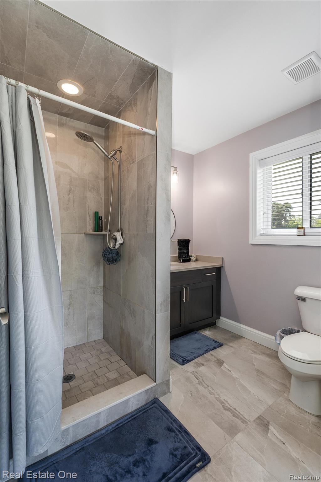 2983 28 Mile Road Washington, MI 48094 - Photo 23 of 54 Tiled walk-in shower with a chrome showerhead and recessed lighting