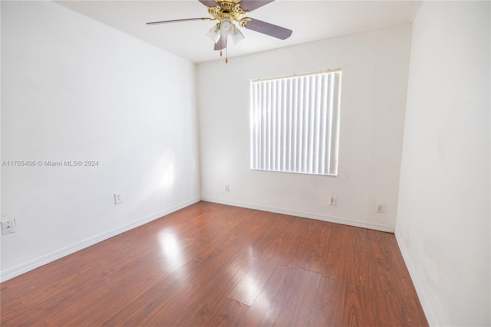24622 Southwest 112th Court Homestead, FL 33032 - Photo 11 of 22 an empty room with wooden floor fan and windows