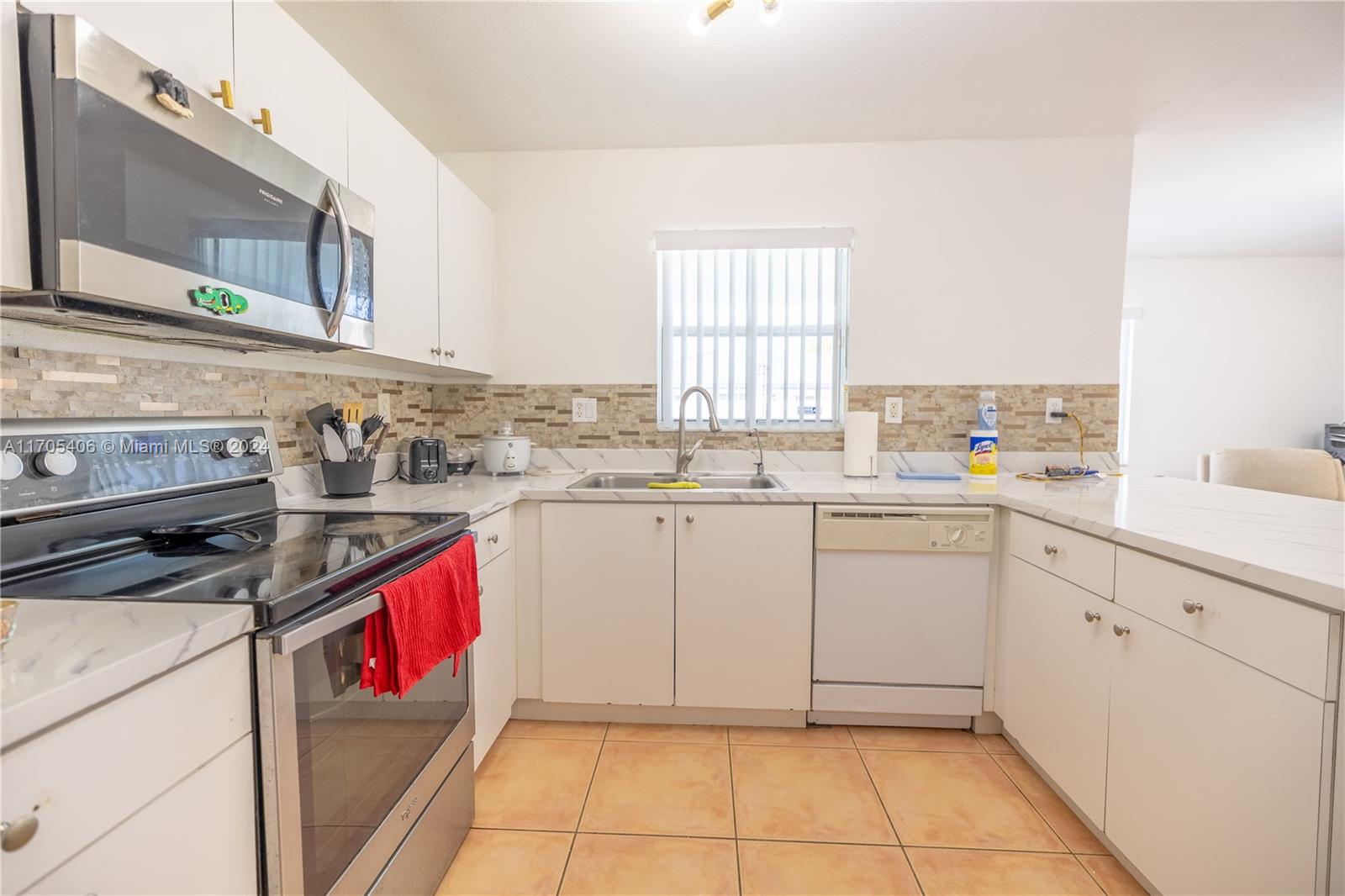 24622 Southwest 112th Court Homestead, FL 33032 - Photo 6 of 22 a kitchen with granite countertop a sink stove and cabinets