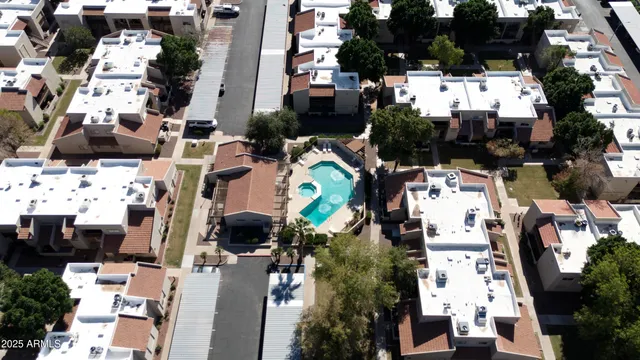 an aerial view of a house a yard patio swimming pool and outdoor seating