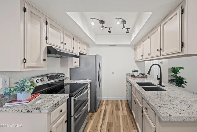 a kitchen with stainless steel appliances granite countertop a sink stove and refrigerator