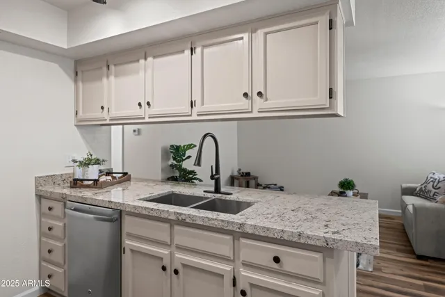 a kitchen with granite countertop a sink and cabinets
