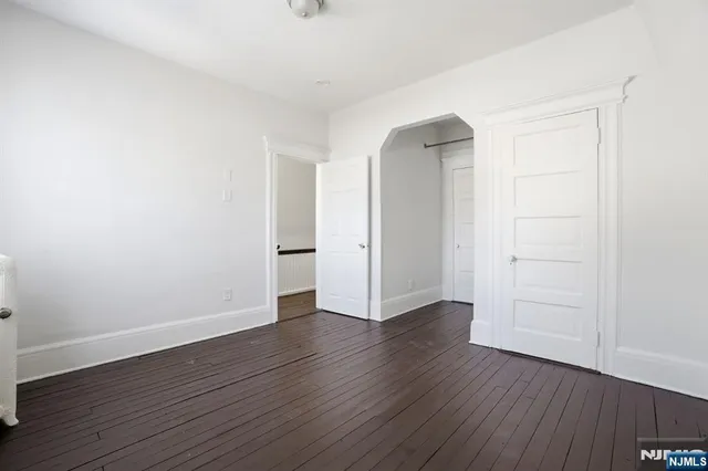 an empty room with wooden floor and closet