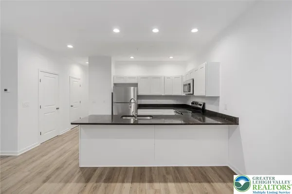 a kitchen with stainless steel appliances a refrigerator sink and microwave