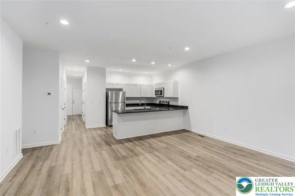 a kitchen with stainless steel appliances granite countertop a sink and a refrigerator