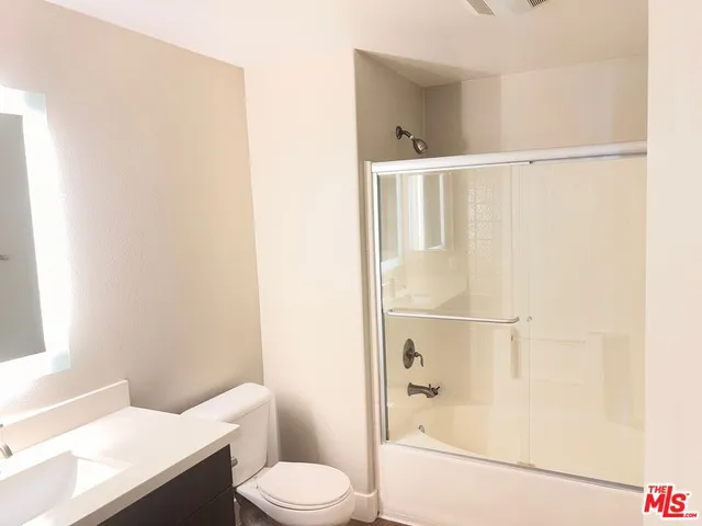 a white toilet sitting next to a bath tub