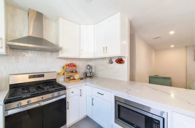 a kitchen with a stove and white cabinets