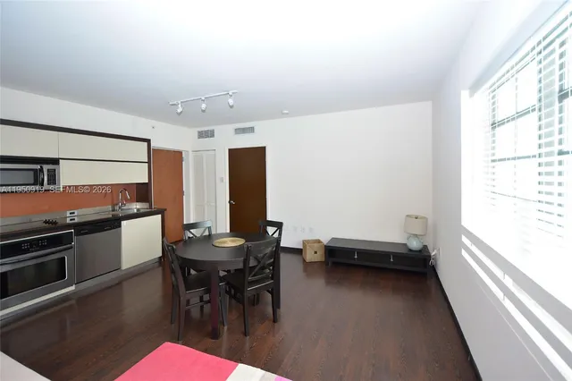 a kitchen with a table chairs and a window