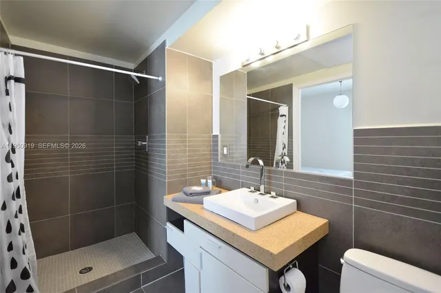 a bathroom with a sink toilet and shower