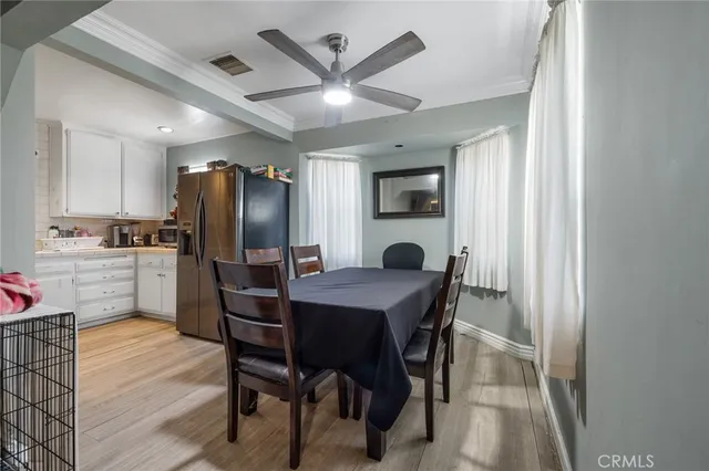 a kitchen with stainless steel appliances refrigerator dining table and chairs