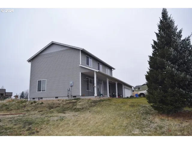a view of a house with backyard and trees