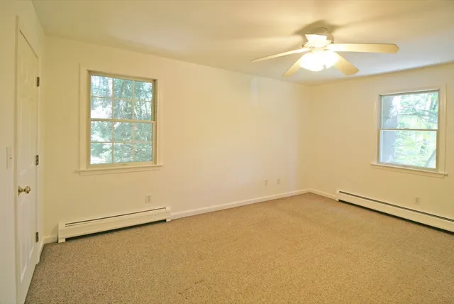 an empty room with a window and a chandelier fan