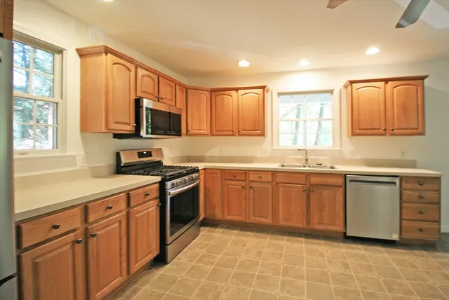 a kitchen with stainless steel appliances granite countertop a stove sink and microwave