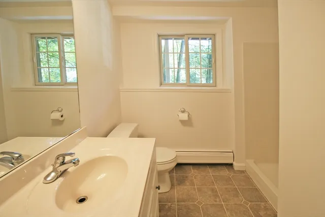 a bathroom with a sink a toilet and a window